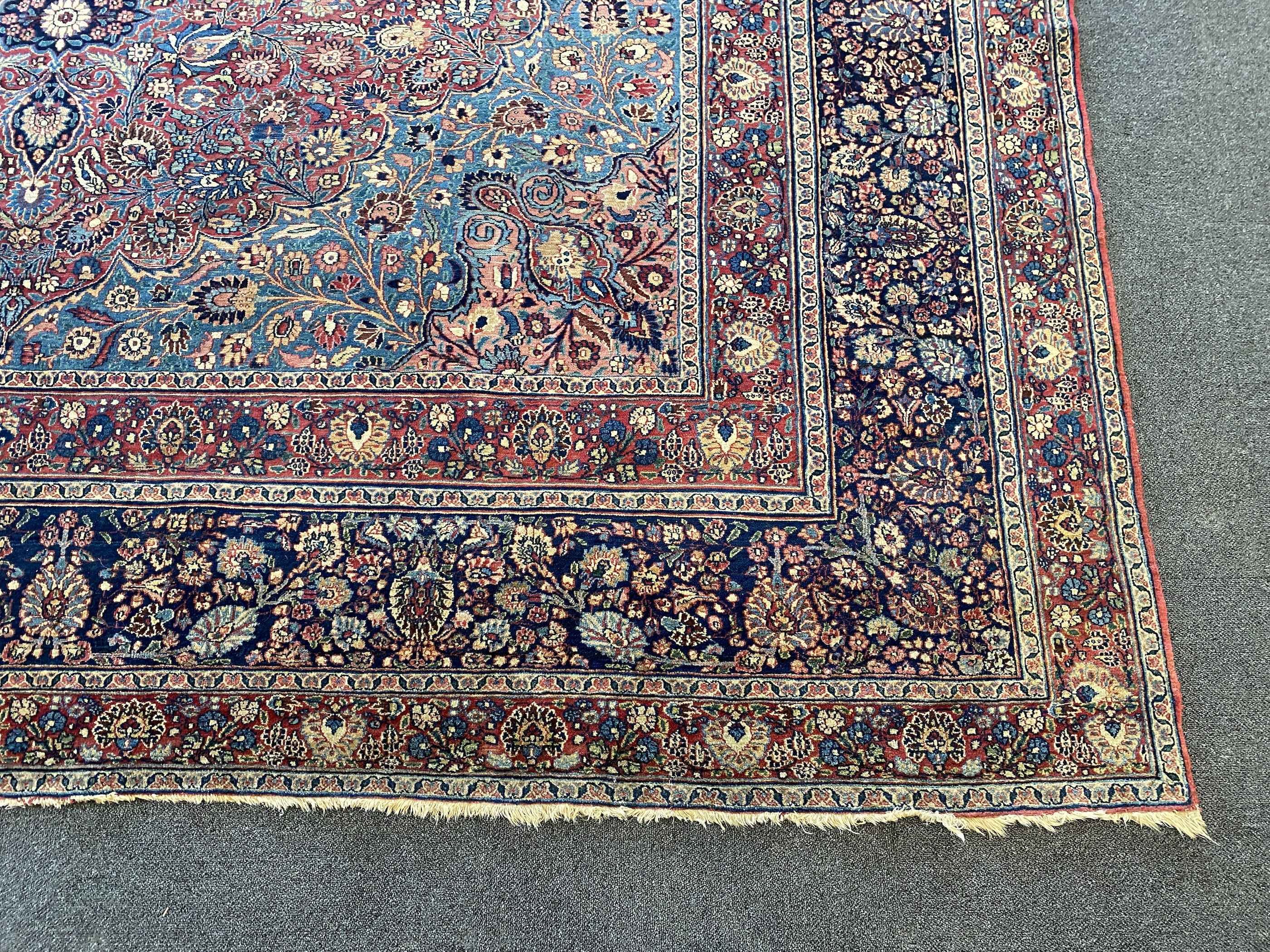 A large Persian blue ground carpet, 395 x 305cm